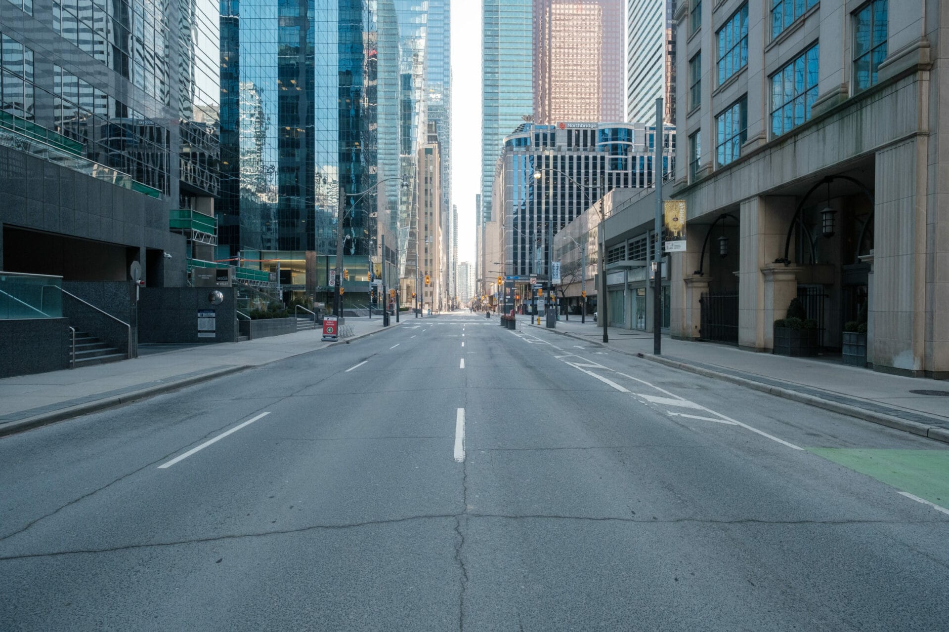 Empty road in between tall city buildings