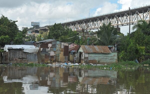 Figure 1. Typical structures in La Barquita before resettlement, constructed incrementally using recycled and found materials. The settlement, located on the floodplains of the Ozama River, was surrounded by waste and prone to environmental hazards. Source: Gobierno Danilo Medina.
