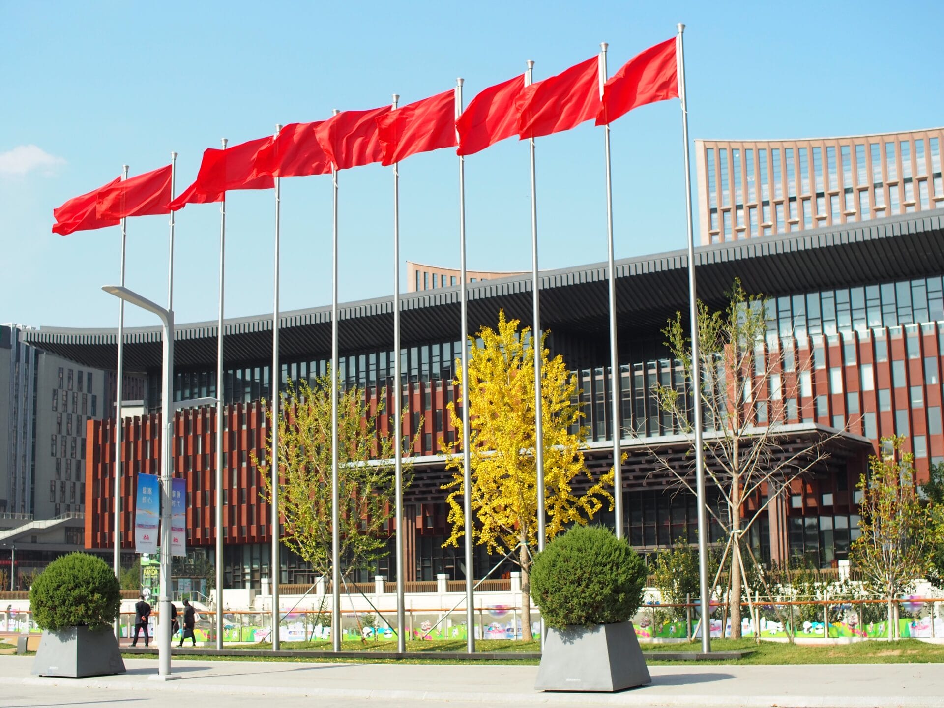 Red flags in front of a building and trees